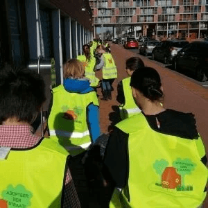 Kinderen met veiligheidshesjes aan